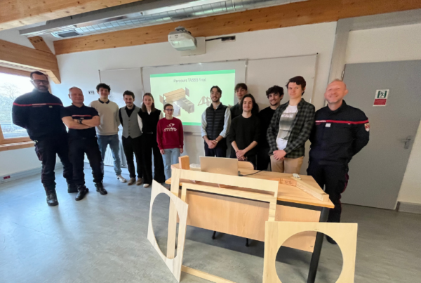 Un groupe d’étudiants de l’ESB et de sapeurs-pompiers pose ensemble dans une salle de cours devant la présentation du projet de parcours TASSS.