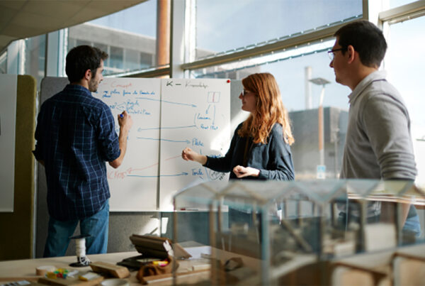 Deux étudiants et leur enseignant travaillent devant un tableau blanc à l’École Supérieure du Bois (ESB).